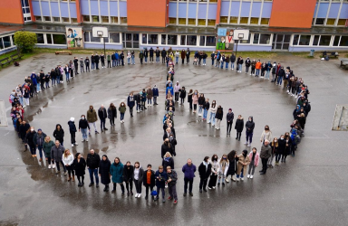 Die Schülerinnen und Schüler bilden im Mai 2022 ein Peace-Zeichen auf dem Schulhof