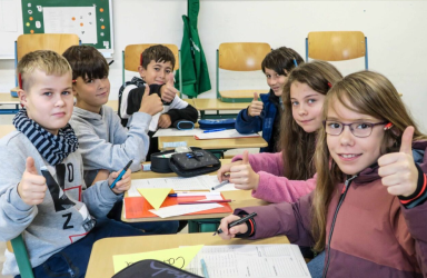 Eine Schülergruppe zeigt 'Daumen hoch'