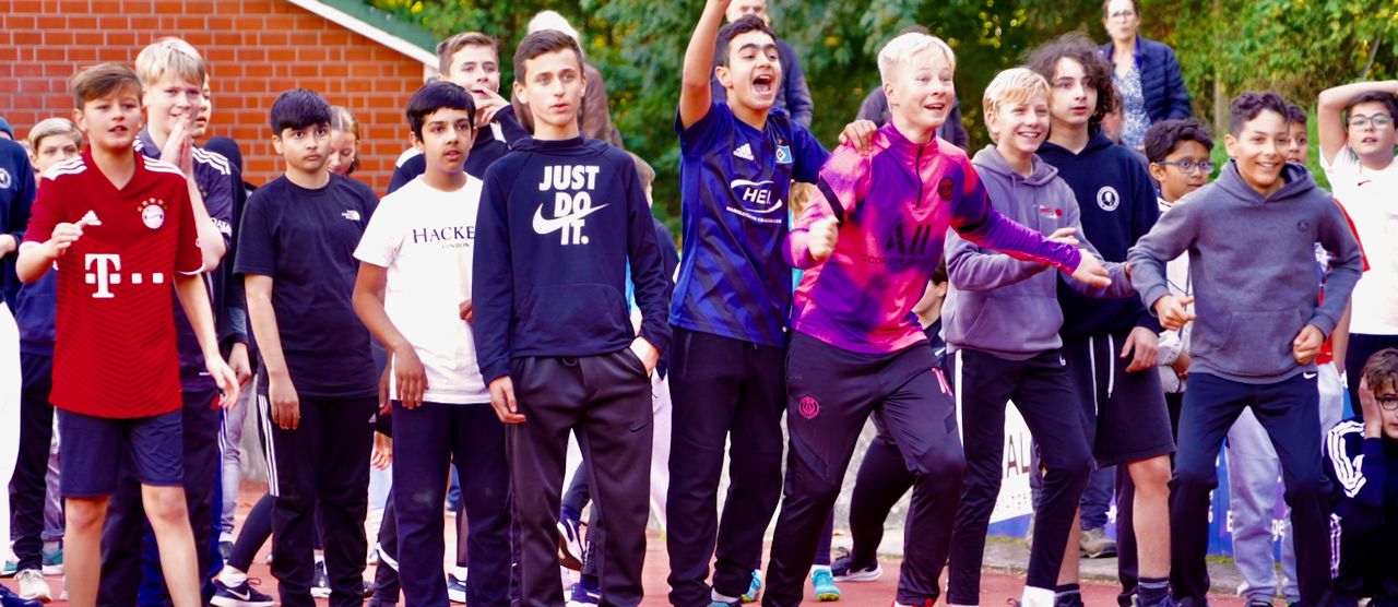 Eine Schülergruppe feuert die Teilnehmer des Staffellauf beim Sportfest an
