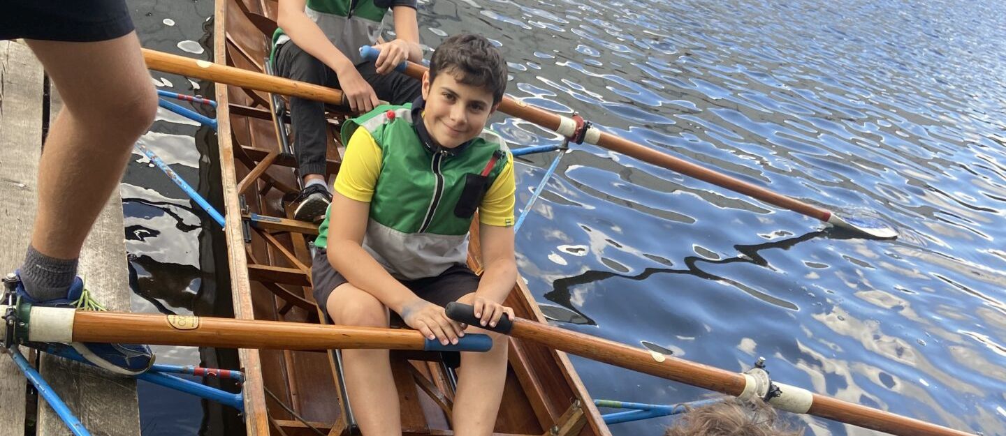 Schüler im Ruderboot am Anleger