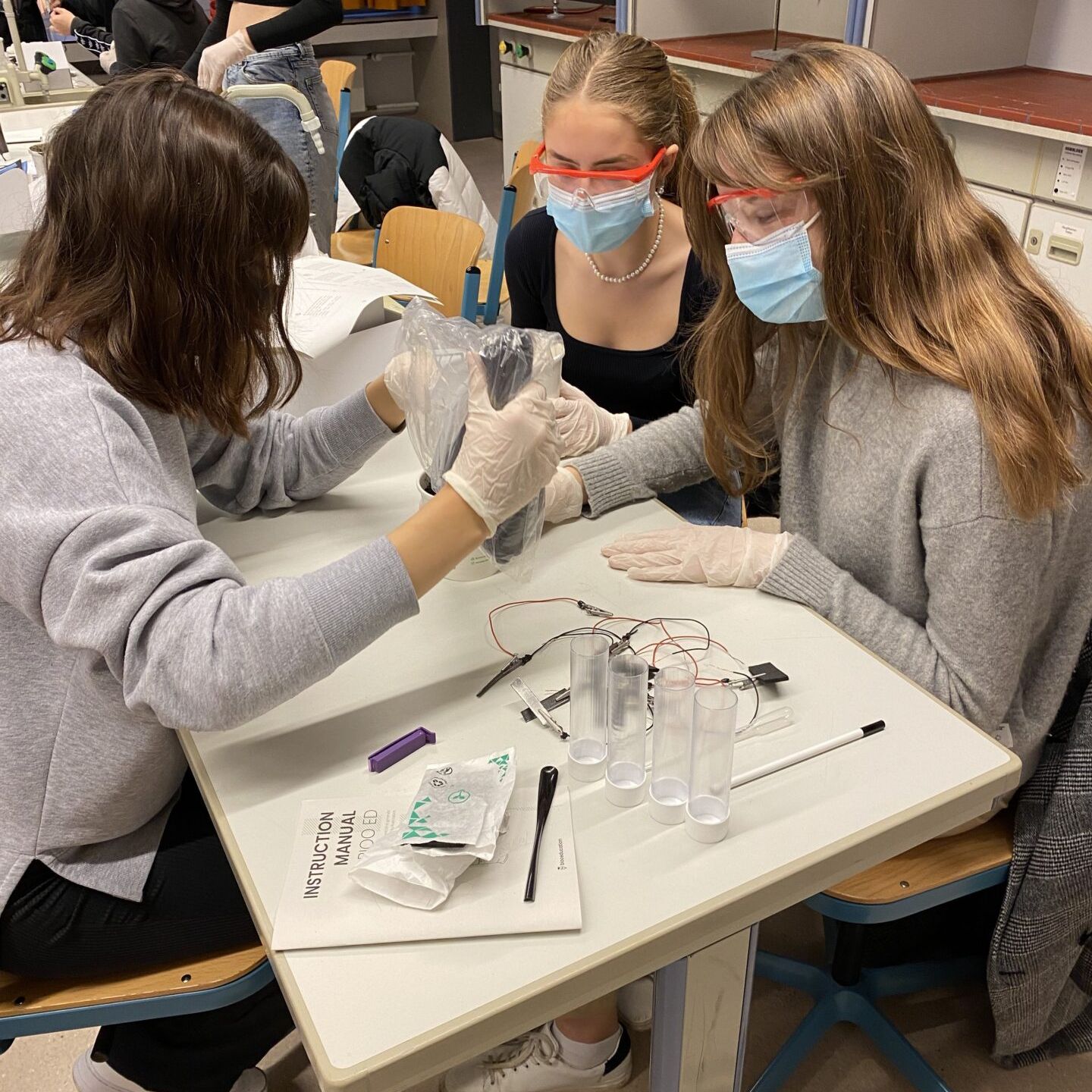 Drei Schülerinnen im Chemieunterricht