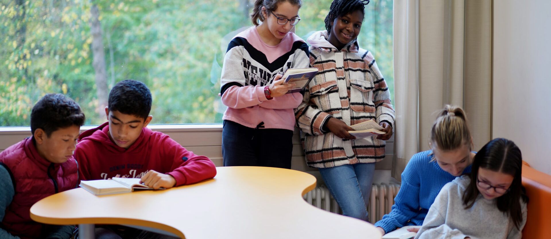 Schülerinnen und Schüler während der Pause in einer Leseecke